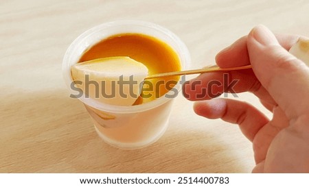 Scooping a simple custard pudding with a spoon