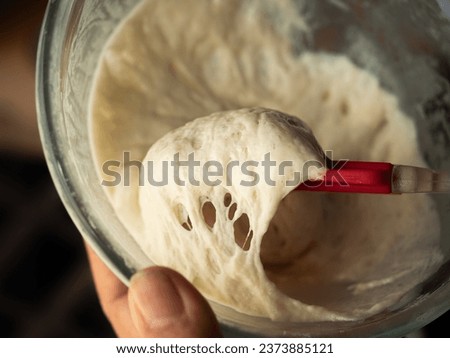 scooping sourdough bread starter with spatula
