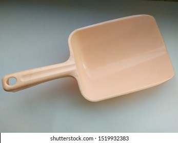 Scoop.Plastic pink scoop for bulk products.Light background.