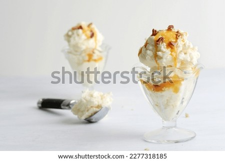 scoops of vanilla ice cream with pecans and caramel sauce