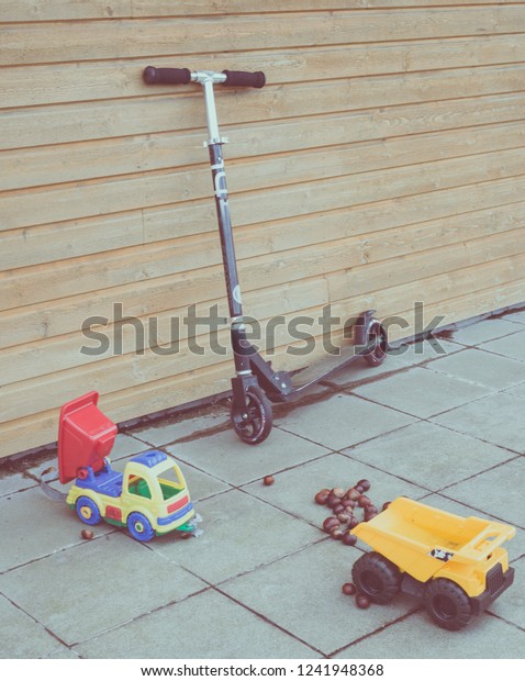Scooter and old plastic truck toys on the balcony.\
Vintage image.