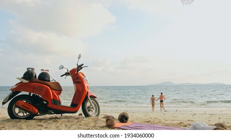 Scooter road trip. Lovely couple on red motorbike in white clothes on sand beach. Just married people kiss hugs walking near the tropical palm trees, sea. Wedding honeymoon by ocean. Motorcycle rent. - Powered by Shutterstock