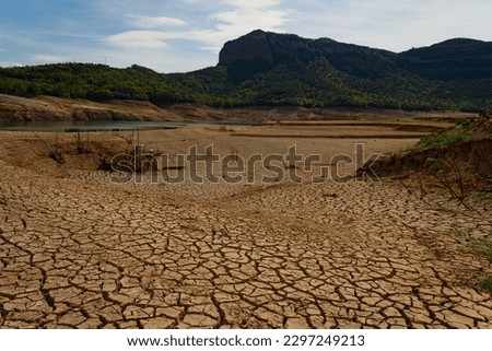 Scorched earth and earth clods are seen on dry land caused by drought and lack of rain due to climate change. Concept of water shortage and climate crisis, cracked earth and dry soil.