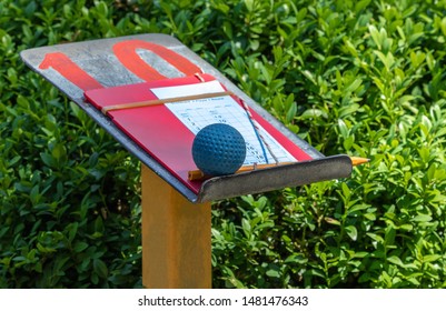 Scorecard And Golf Ball On Stand With Number 10 For Playing Mini Golf