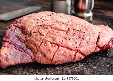 Scored and Seasoned Whole Picanha Closeup: Picanha with a scored fat cap seasoned with kosher salt and black pepper - Powered by Shutterstock