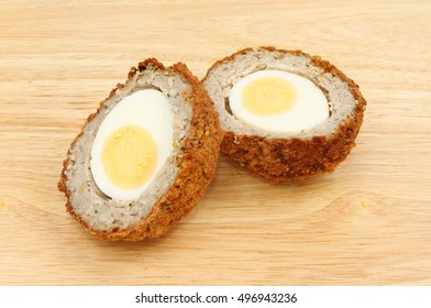 Scotch Egg Cut In Half On A Wooden Chopping Board