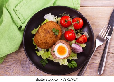 Scotch eggs on a plate with cherry tomatoes and salad. View from above, top studio shot, horizontal - Powered by Shutterstock