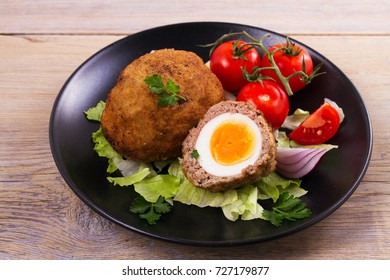 Scotch eggs on a plate with cherry tomatoes and salad, horizontal - Powered by Shutterstock