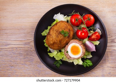 Scotch eggs on a plate with cherry tomatoes and salad. View from above, top studio shot, horizontal - Powered by Shutterstock