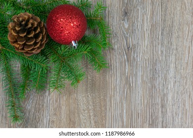 A Scotch Pine Cone And A Red Ornament On Spruce Boughs With Copy Space