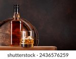 Scotch whiskey bottle, glass and old wooden barrel. With copy space