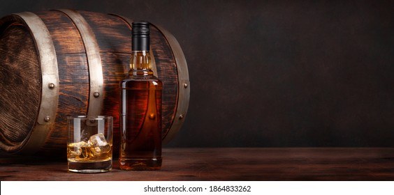 Botella de whisky escocés, vidrio y barril de madera viejo. Con espacio de copia