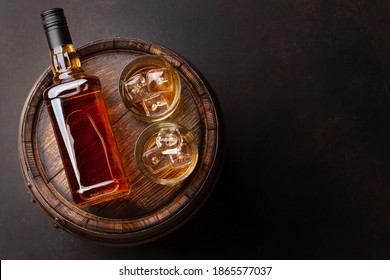 Scotch whiskey bottle, glass and old wooden barrel. With copy space. Top view flat lay
