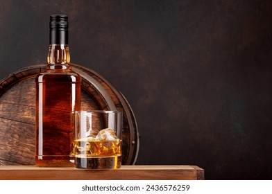 Scotch whiskey bottle, glass and old wooden barrel. With copy space