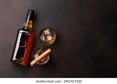 Scotch whiskey bottle, glasses and cigar. With copy space. Top view flat lay
