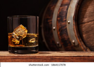 Scotch Whiskey Glass And Old Wooden Barrel