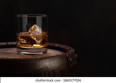Scotch whiskey glass and old wooden barrel. With copy space