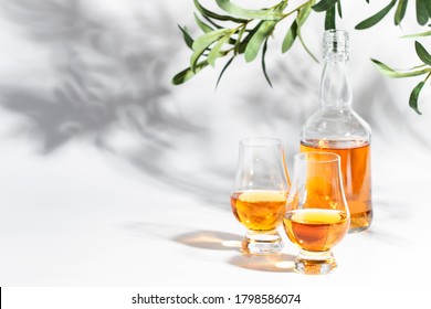 Scotch Whiskey Without Ice In Glasses And Bottle, White Background With Hard Light, Shadows And Sun Glare, Copy Space 
