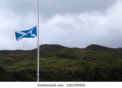 The Scotland Flag Against A Cloudy Sky And Mountains. 