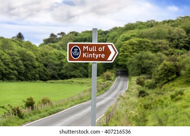 Scotland, Kintyre: Street scene with traffic sign to famous Scottish tourist attraction Mull of Kintyre with green nature and blue sky in the background. June 28, 2015 