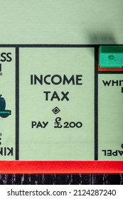 Scotland, UK - February 12 2021;  The Pay Income Tax Square On A UK Monopoly Board