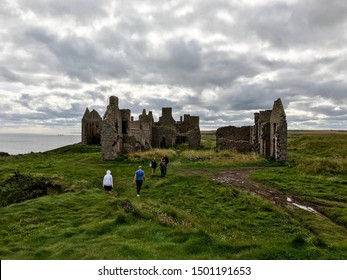 Scotland, UK - September 8, 2019 : Group of people walking towards Slains Castle in Cruden bay, Peterhead. The Castle believed to be the inspiration to Bram Stoker for his story Count Dracula (1897).