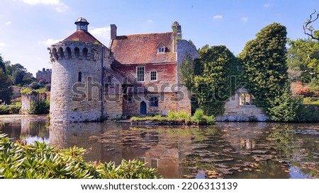 Scotney Castle reflected in moat on summer's day, Kent, UK