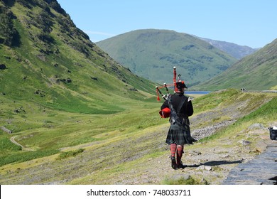 A Scotsman Playing Bagpipes In Scottish Highlands