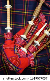 Scottish folk antique musical instrument bagpipes and colorful tartan fabric close up