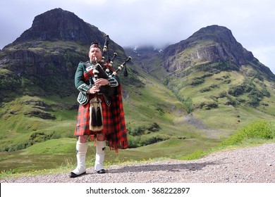 SCOTTISH HIGHLANDS - JUNE 15: Piper in traditional Scottish outfit plays on bagpipes in somewhere in Scottish Highlands, United Kingdom on June 15, 2013.