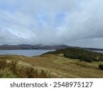 Scottish highlands view across a loch low misty clouds spectacular trees fields