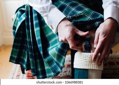Scottish Man Is  Getting Dressed With Traditional Kilt 