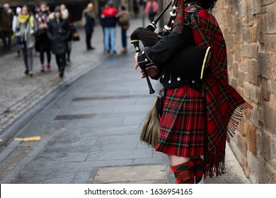 Scottish Piper Playing The Bagpipes In Traditional Costume In Edinburgh