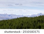 Scottish snow capped Mountain landscape with a dense forest on show from the Glengarry viewpoint in the Scottish Highlands