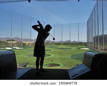 Scottsdale, Arizona, USA - September 20 2020: The silhouette of a person playing at the TopGolf driving range on a sunny day