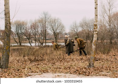 Scouts Of Red Army Men Make Their Way Through The Autumn Field To The Enemy. Reconstruction Of The Liberation Of The City Of Gomel