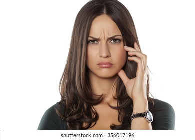 scowling young woman posing on a white background - Shutterstock ID 356017196