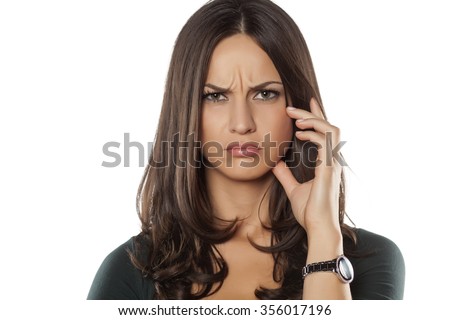 scowling young woman posing on a white background