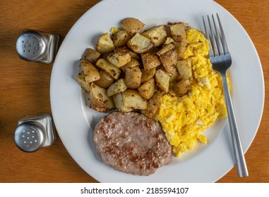 Scramble Eggs Served With Home Fries And Sausage Patty