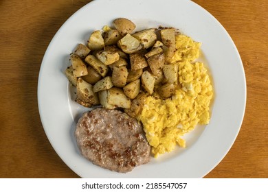 Scramble Eggs Served With Sausage Patty And Home Fries