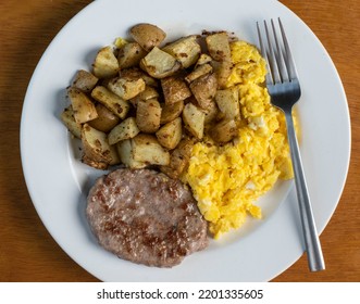 Scramble Eggs Served With Sausage Patty And Home Fries