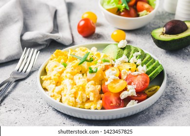 Scrambled eggs with cherry tomatoes , avocado feta cheese and olive oil.Selective focus, space for text. - Powered by Shutterstock