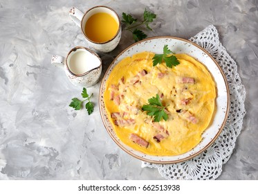 Scrambled Eggs With Ham And Cheese On A Gray Textured Background. Top View. Copy Space.