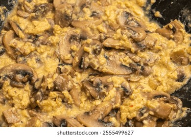 Scrambled eggs with sautéed mushrooms cooking in a frying pan. A close-up of a healthy, protein-rich breakfast with vibrant textures and colors, perfect for culinary or food-related concepts. - Powered by Shutterstock