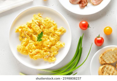 Scrambled eggs on plate over light stone background.  Top view, flat lay