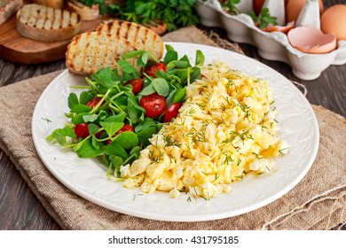 Scrambled Eggs On Plate With Vegetables And Grilled Toast.