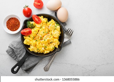 Scrambled Eggs On Skillet Over Gray Stone Background.