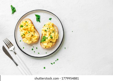 Scrambled Eggs On Toasted Bread For Healthy Breakfast Or Brunch On White Background, Top View, Copy Space. 