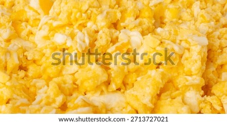 Scrambled eggs pattern, omelet wallpaper. Breakfast fried eggs stirred or beaten together with salt and butter. Morning hot omelette, fresh omlet top view