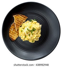 Scrambled Eggs With Toast On Black Plate. Top View, Isolated On White.